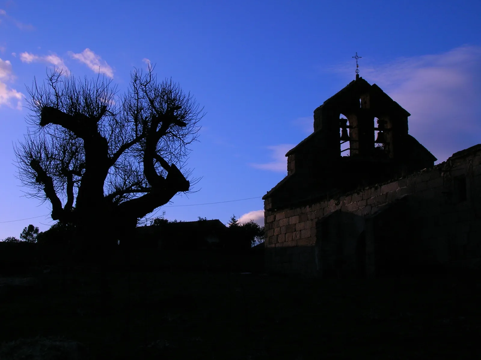 Antigua iglesia de San Miguel y una encina al atardecer